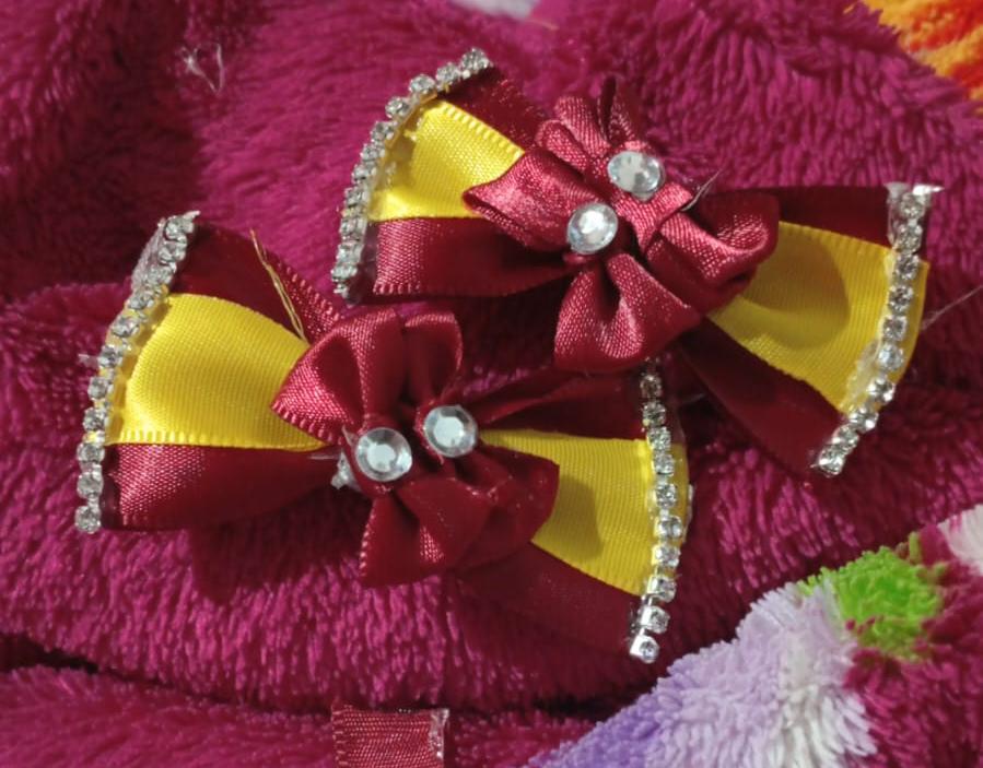 imagem de um conjunto de laços de cabelo vermelho e amarelo com pedrinhas decorativas